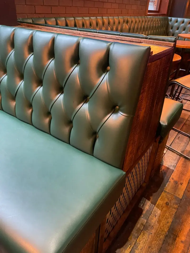 Buttoned leather banquette against panelling
