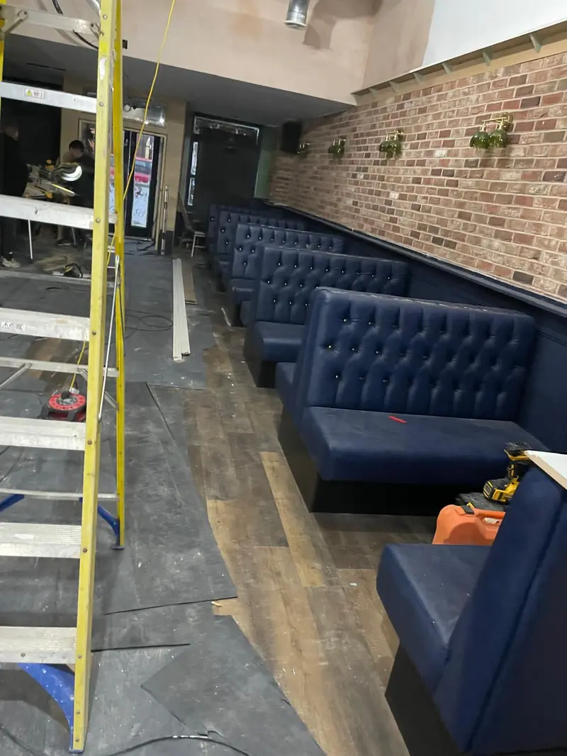 Navy buttoned banquette against exposed brick